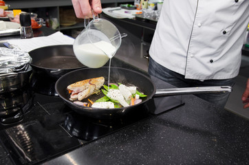 Chef preparing dishes in a frying pan