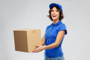 mail service and shipment concept - happy smiling delivery girl with parcel box in blue uniform...