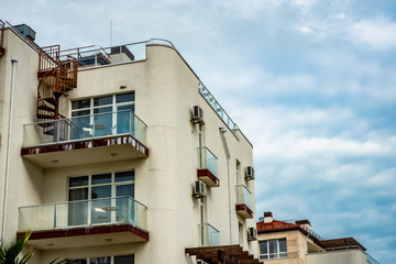 Fototapeta na wymiar Building top with a balcony on the blue sky background. Imeretinskiy kvartal, Adler district, Sochi, Russia.