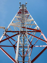 Ladder or steps on a transmission tower towards the bright blue sky.