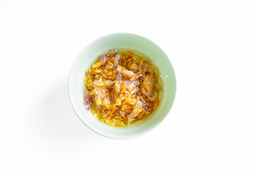 Deep fry garlic with oil on isolated white background,fried garlic chips