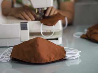 Woman use sew machine to sewing face medical mask protective against during the dust PM 2.5, coronavirus Epidemic, virus covid-19 work Home at home made DIY