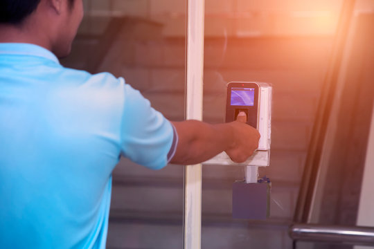 The hand are scanning on fingerprint machine for enter digital security door system in the office building at Bangkok ,Thailand.  Fingerscan with access control on the glass door.