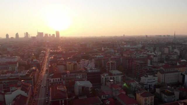 Drone aerial view of Milan skyline from above with colourful sunset over the city. Shot in Lambrate area during Coronavirus lockdown quarantine. Moving panning left.