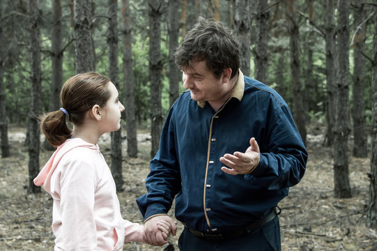 A teenage girl is talking in the woods with a man who offers to go with her. The concept of kidnapping.