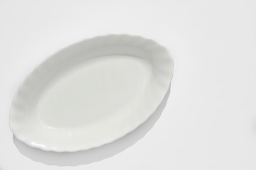 Empty white long oval plate on white background, copy space, top view, blank