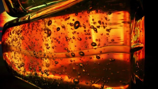 Abstract background - static shot of back lit hand sanitizer bottle on its side. Background colors changing four times to show great detail inside the hand sanitizer bottle; lots of air bubbles.