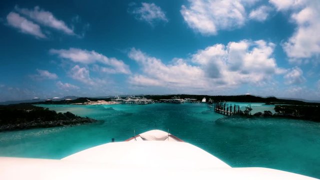 Hyperlapse of mega yacht pulling into harbor on clear blue water of Bahamas