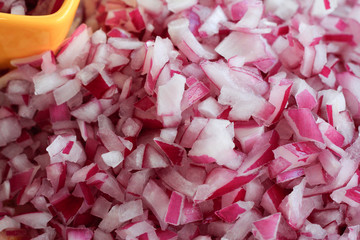 Fresh chopped red onion on cutting board texture close up