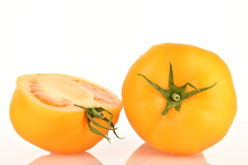 Ripe juicy yellow tomatoes, close-up, on a white background.