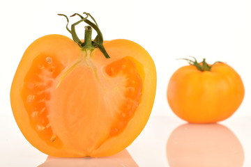 Ripe juicy yellow tomatoes, close-up, on a white background.