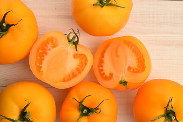 Ripe juicy yellow tomatoes on a painted white table.