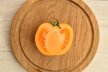 Ripe juicy yellow tomatoes on a painted white table.