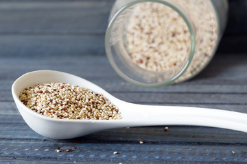 uncooked quinoa seeds in white spoon on the table