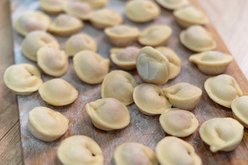 Frozen russian crude pelmeni laid out on a wooden board-2.