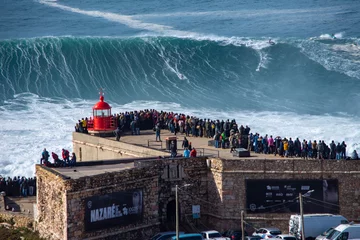 Fotobehang Nazare has one thing which attracts thousands of tourists and just few surfers who are brave and crazy enough to ride the biggest waves on our planet. © Alex
