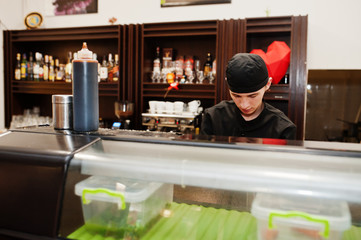 Professional chef wear in black making sushi and rolls in a restaurant kitchen of japanese traditional food.
