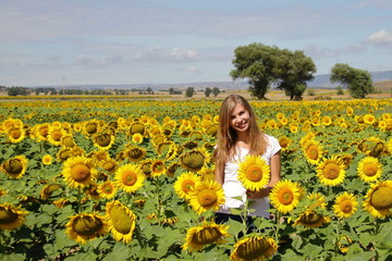 Fototapeta na wymiar smiling young woman in field sunflowers, without filters, farming time in countryside 