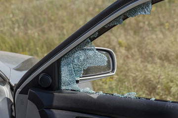 Criminal incident. Hacking a car. Broken driver's side window of car. Thieves smashed window of car...