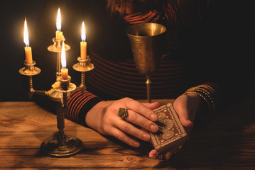 Tarot card in fortune teller hands close up.