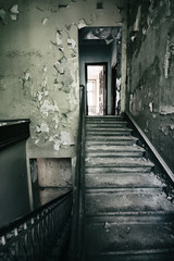 Old staircase in an abandoned building with shabby walls