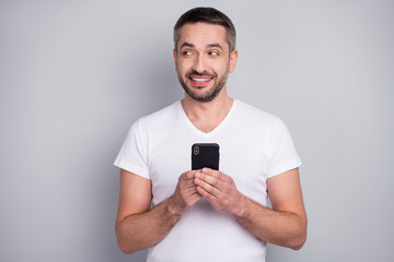 Close-up portrait of his he nice attractive creative curious cheerful cheery guy using digital device app 5g creating media feedback isolated over light grey pastel color background