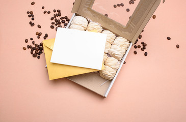 A box of marshmallows, a yellow envelope with a white postcard for text.