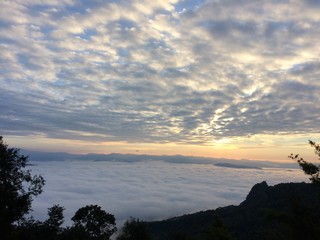 Beautiful view of the blue sky, mist in the morning sun on the mountain on the background. Sun rise seen from a mountain top in Nan, Thailand.