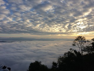 Obraz premium Beautiful view of the blue sky, mist in the morning sun on the mountain on the background. Sun rise seen from a mountain top in Nan, Thailand.