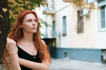 Ginger woman with long hairs in hand, close up.