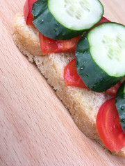 sandwich with bread with tomatoes and cucumbers on a wooden table.