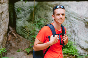 Naklejka premium Young male hiker with backpack. Active healthy lifestyle adventure journey vacations