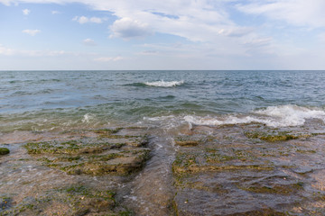 Natural strait between rocks, by the sea on a bright day with waves. 
