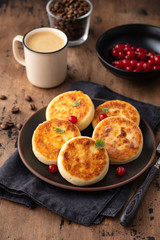 Cottage cheese pancakes Russian syrniki with red currant and yogurt, selective focus.