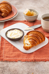 Fresh croissants with blueberries and honey, gray background.