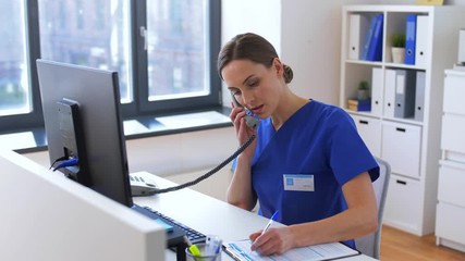 medicine, technology and healthcare concept - female doctor or nurse with computer calling on phone at hospital - Powered by Adobe
