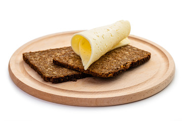 Whole grain black bread with cheese on a wooden board. Isolate on white background