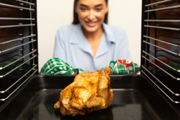 View from inside on roasted chicken in oven and housewife