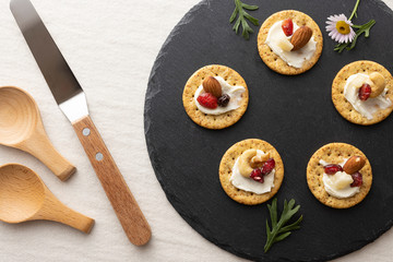 クリームチーズとドライフルーツとナッツが乗ったクラッカー