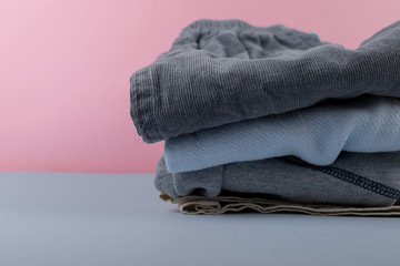 children's clothing after washing machine. iron clothes folded in a pile of clothing & soft pink background color