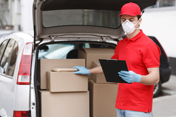 Fast auto delivery concept. Courier checks parcel in car and tablet