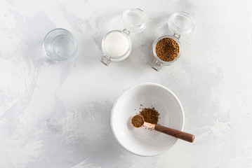 Dalgona coffee cooking step by step recipe. Step 2. Adding coffee to the bowl on white background. Top view