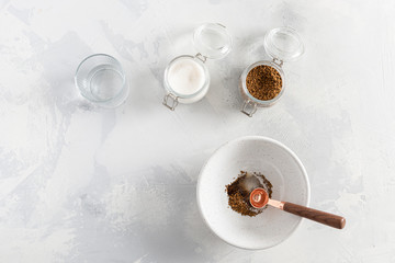 Dalgona coffee cooking step by step recipe. Step 4. Adding water to the bowl on white background. Top view.