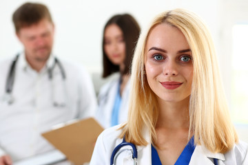 Beautiful smiling female doctor stand in office portrait