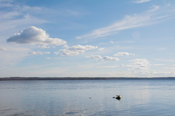 Fototapeta na wymiar Stone lies in water under a blue sky