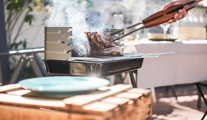 Chef grill t-bone steak at barbecue sunday lunch outdoor - Man cooking meat for a family bbq meal...