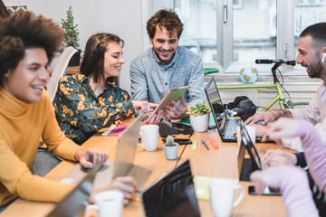 Young co-workers team talking during startup - Happy people planning a new project in creative coworking office - Technology, entrepreneur, marketing, smart working concept - Focus on center man face