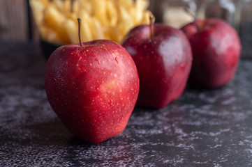 Red apples on the black cement floor. Selective focus.