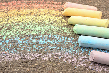 The rainbow is drawn on the asphalt, sidewalk with colored crayons, chalks