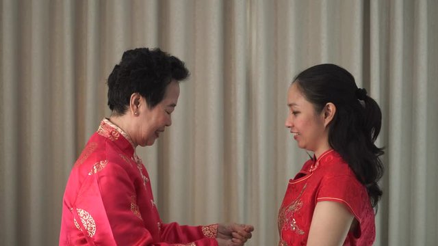 Mother give gift jad necklace to daughter on Chinese New Year